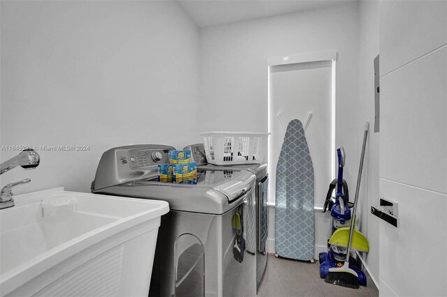 laundry room with sink, washing machine and clothes dryer, and tile patterned flooring