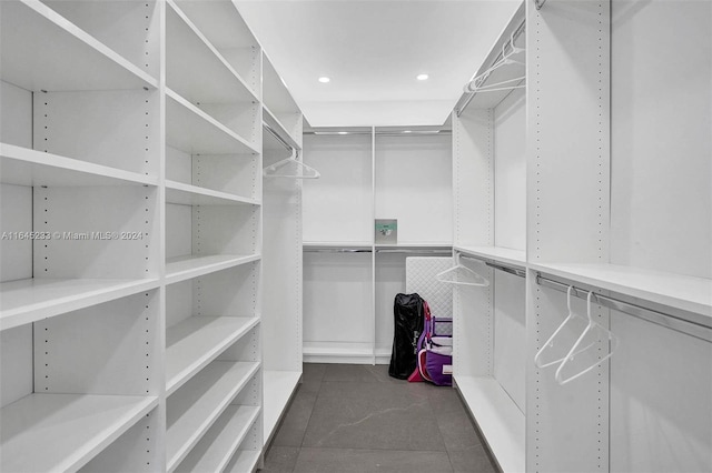 spacious closet featuring dark tile patterned flooring