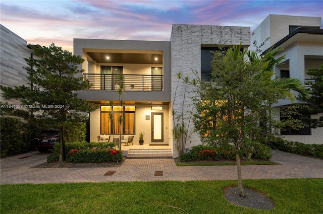 contemporary house with a yard and a balcony