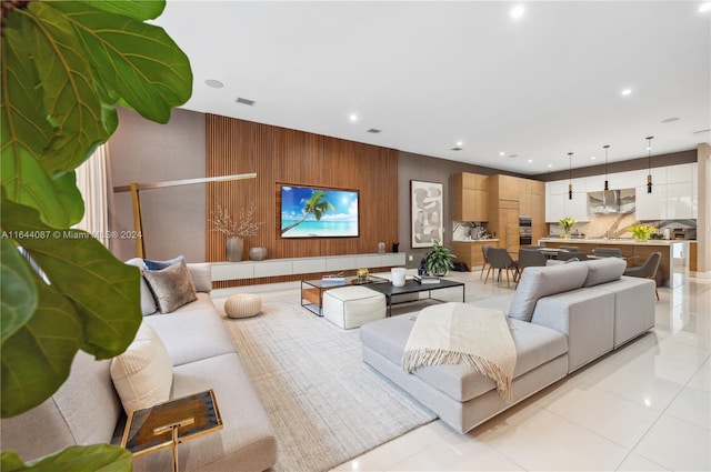 living room featuring sink, wood walls, and light tile patterned flooring