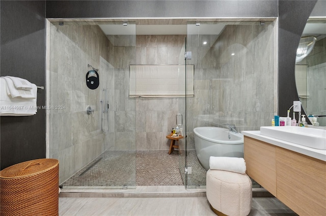 bathroom with plus walk in shower, tile patterned flooring, and vanity