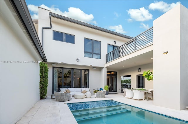 back of house featuring a balcony, an outdoor living space, and a patio area