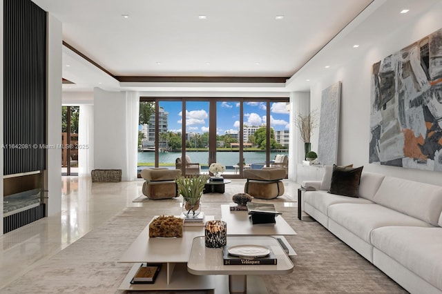 living room with a tray ceiling and a water view