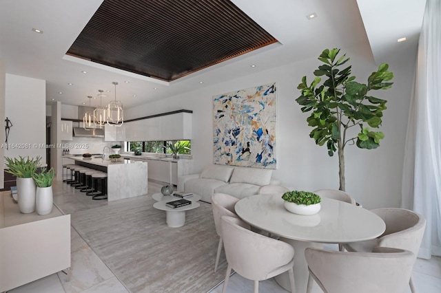 dining space with a tray ceiling and a chandelier