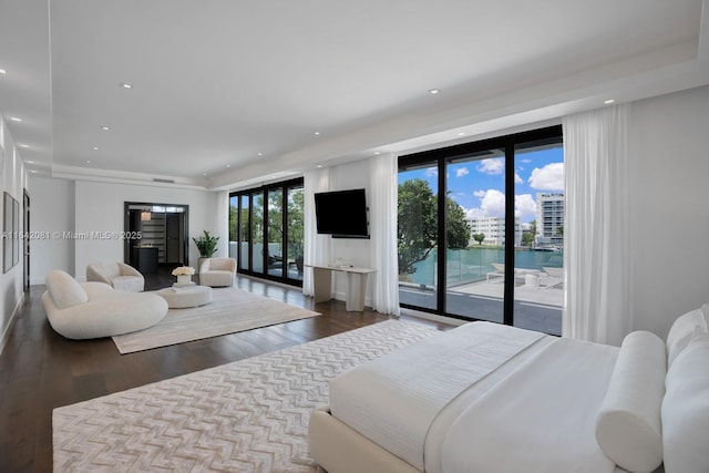 bedroom with access to outside, floor to ceiling windows, and dark hardwood / wood-style floors