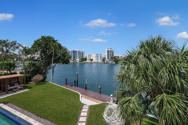 view of dock with a yard and a water view