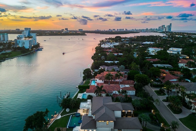 aerial view at dusk featuring a water view