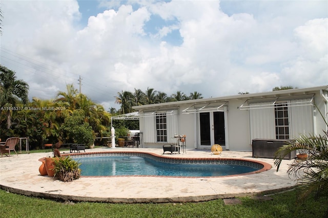 view of swimming pool with french doors and a patio area