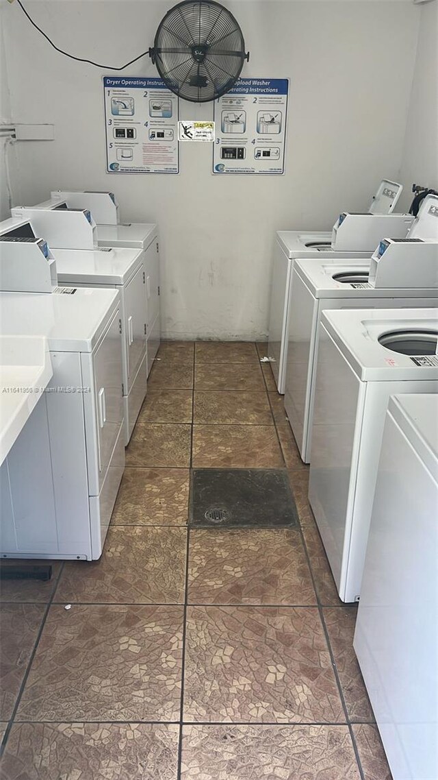 washroom with dark tile patterned flooring and washer and dryer