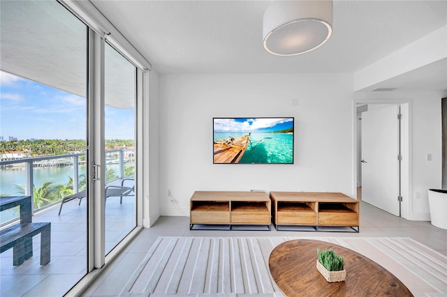 tiled living room featuring expansive windows and a water view