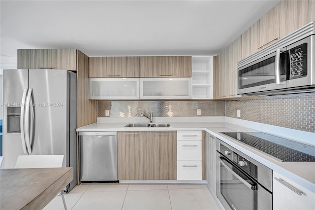 kitchen featuring appliances with stainless steel finishes, sink, backsplash, and light brown cabinetry