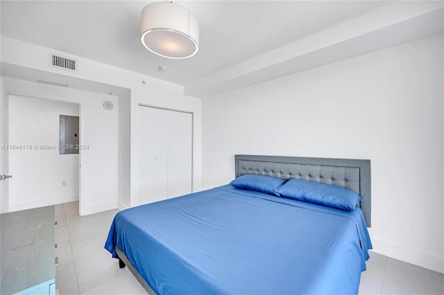 bedroom with a closet, electric panel, and light tile patterned floors