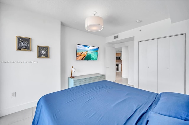 bedroom featuring a closet and light tile patterned floors