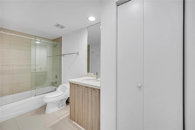 full bathroom featuring tile patterned floors, toilet, shower / bath combination with glass door, and vanity