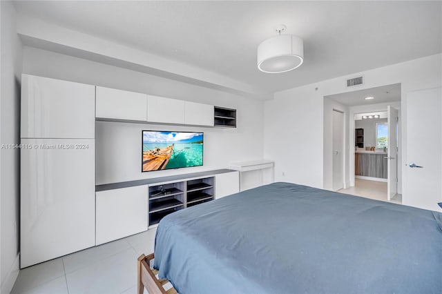 bedroom featuring light tile patterned flooring and ensuite bath