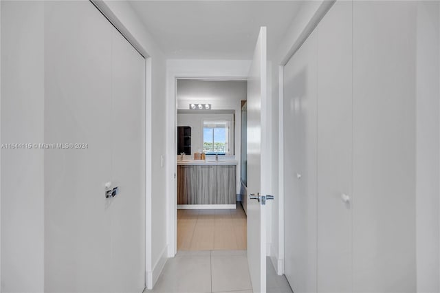 hall with sink and light wood-type flooring