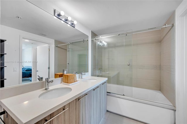 bathroom with shower / bath combination with glass door, double sink vanity, and tile patterned floors