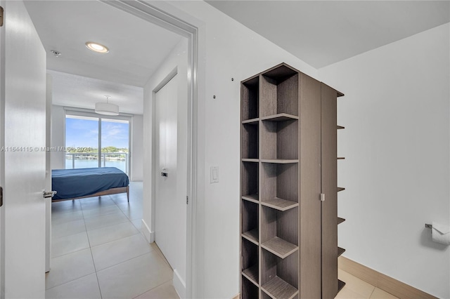 corridor with a water view and light tile patterned floors