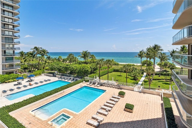 view of pool featuring a lawn and a water view