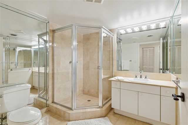 bathroom with tile patterned flooring, vanity, walk in shower, and toilet