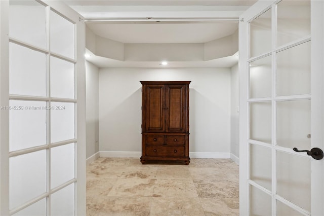 spacious closet with a raised ceiling and light tile patterned floors