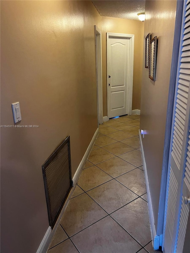 hall featuring light tile patterned floors