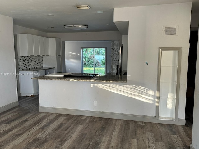 kitchen featuring dark hardwood / wood-style floors, decorative backsplash, and white cabinetry