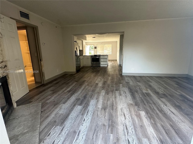 unfurnished living room featuring wood-type flooring and crown molding