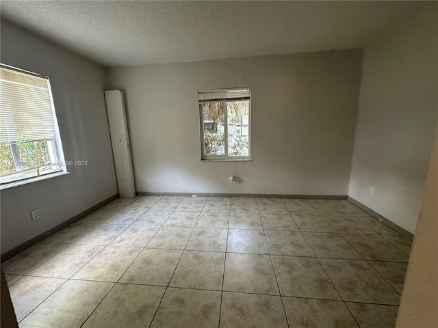 tiled spare room featuring a textured ceiling