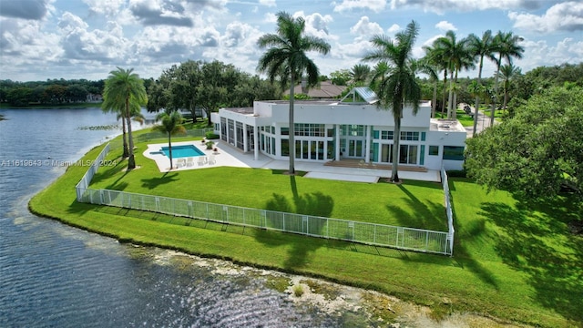 back of house with a water view, a patio, a fenced in pool, and a yard