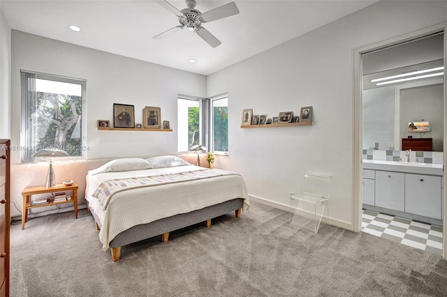 carpeted bedroom featuring multiple windows, sink, and ceiling fan