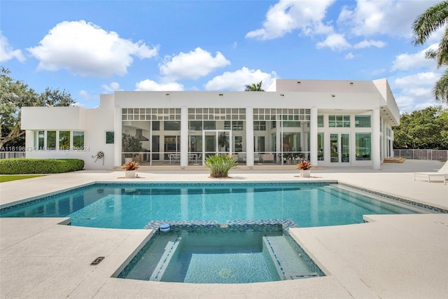 rear view of house with a patio area and a pool with hot tub