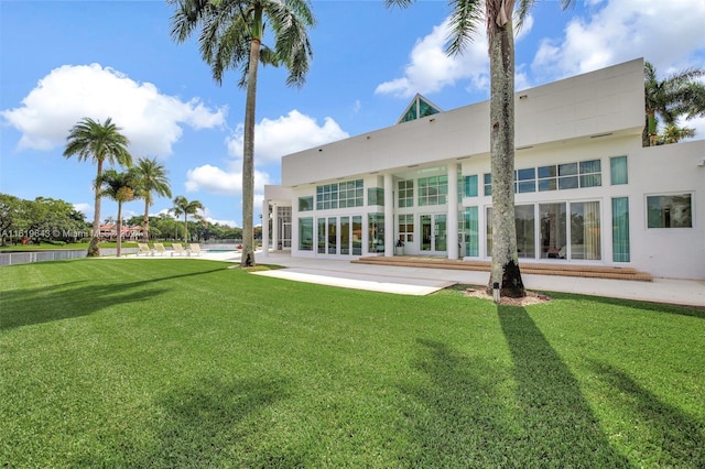 rear view of property with a yard and a patio area