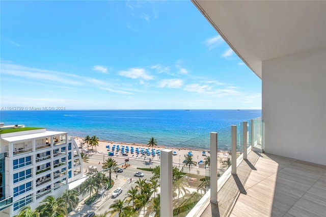 balcony with a water view and a view of the beach