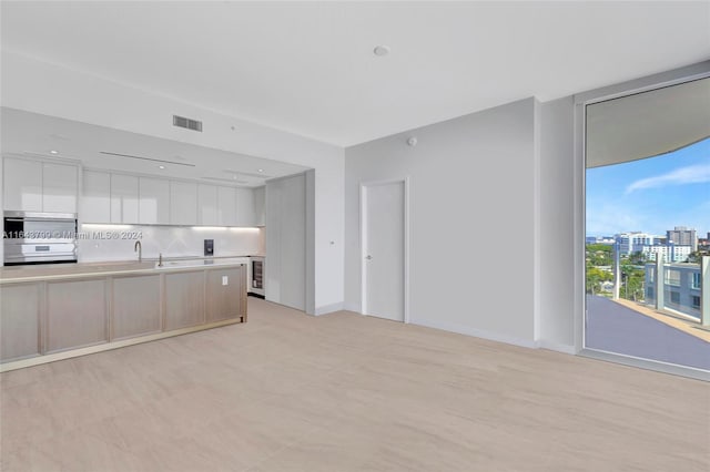 kitchen featuring light tile patterned flooring, tasteful backsplash, and white cabinets