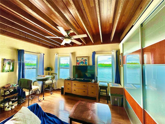 living room with wooden ceiling, a ceiling fan, beamed ceiling, and wood finished floors