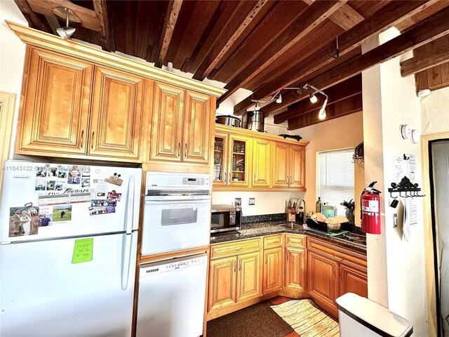 kitchen featuring carpet, beam ceiling, sink, and white appliances