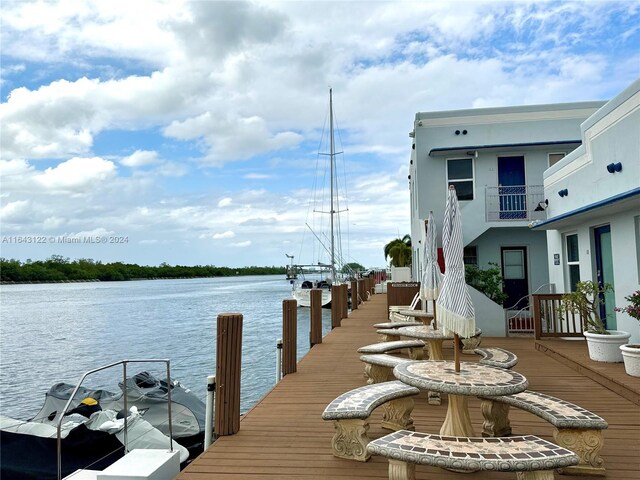 view of dock with a balcony and a water view