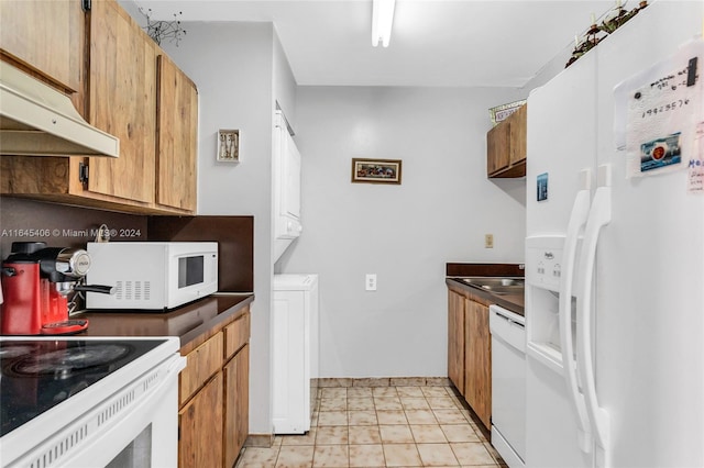 kitchen with white appliances, ventilation hood, sink, stacked washing maching and dryer, and light tile patterned floors