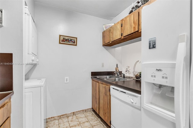 kitchen featuring stacked washer and clothes dryer, sink, light tile patterned floors, and white appliances