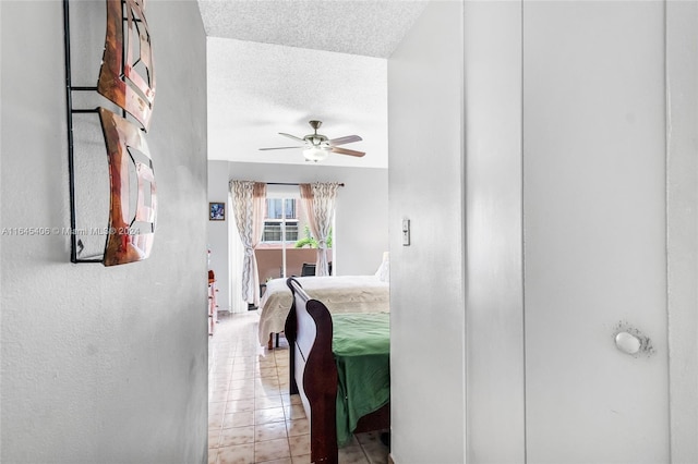 tiled bedroom with ceiling fan and a textured ceiling