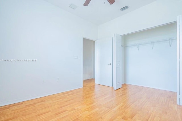 unfurnished bedroom featuring light wood finished floors, visible vents, baseboards, a ceiling fan, and a closet