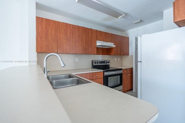 kitchen featuring sink, a textured ceiling, white fridge, and electric range