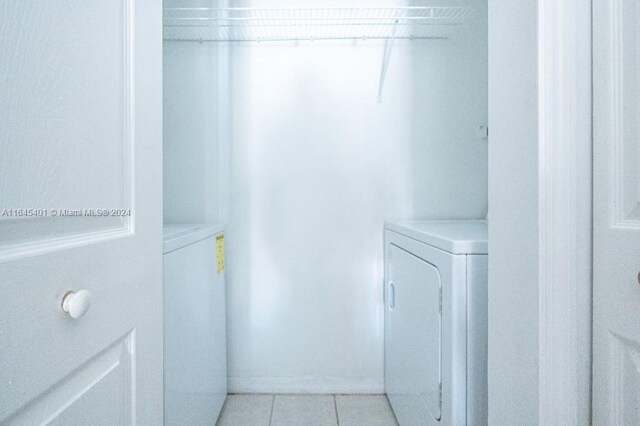 laundry area featuring light tile patterned flooring and washer and clothes dryer