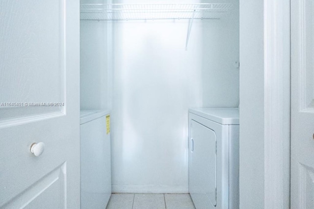 washroom with laundry area, light tile patterned floors, and separate washer and dryer