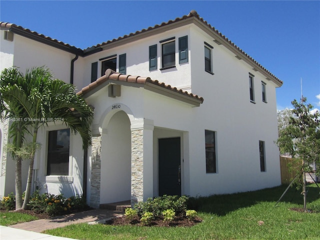 mediterranean / spanish home with a front yard