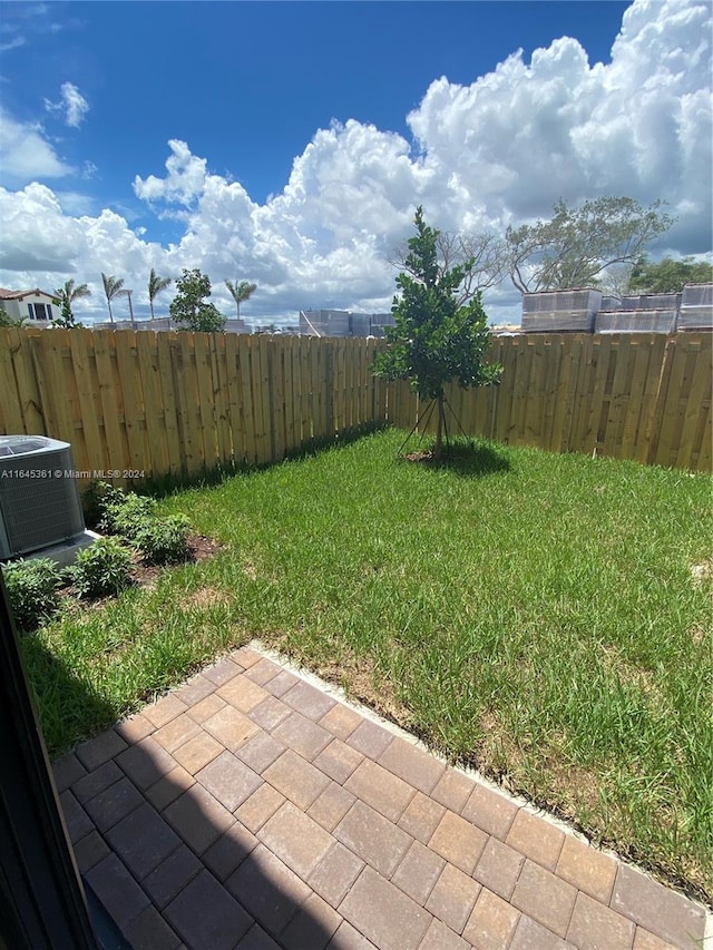 view of yard featuring central air condition unit and a patio