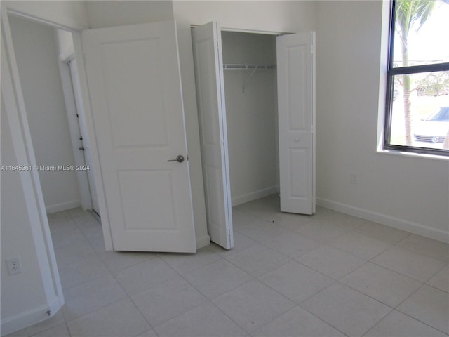 unfurnished bedroom featuring light tile patterned flooring and a closet