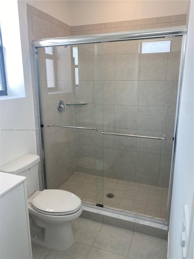 bathroom with tile patterned flooring, toilet, walk in shower, and vanity