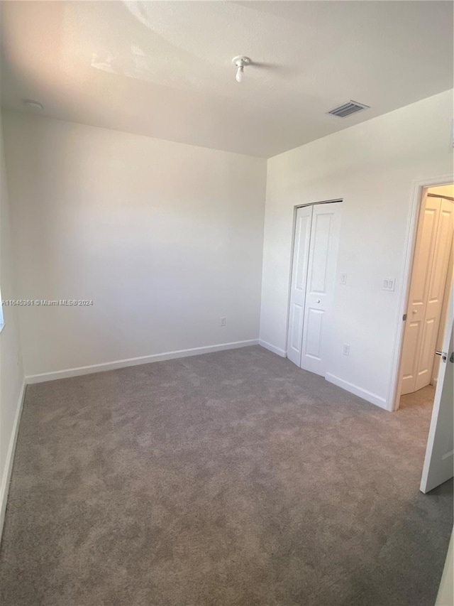 unfurnished bedroom with carpet flooring and a closet